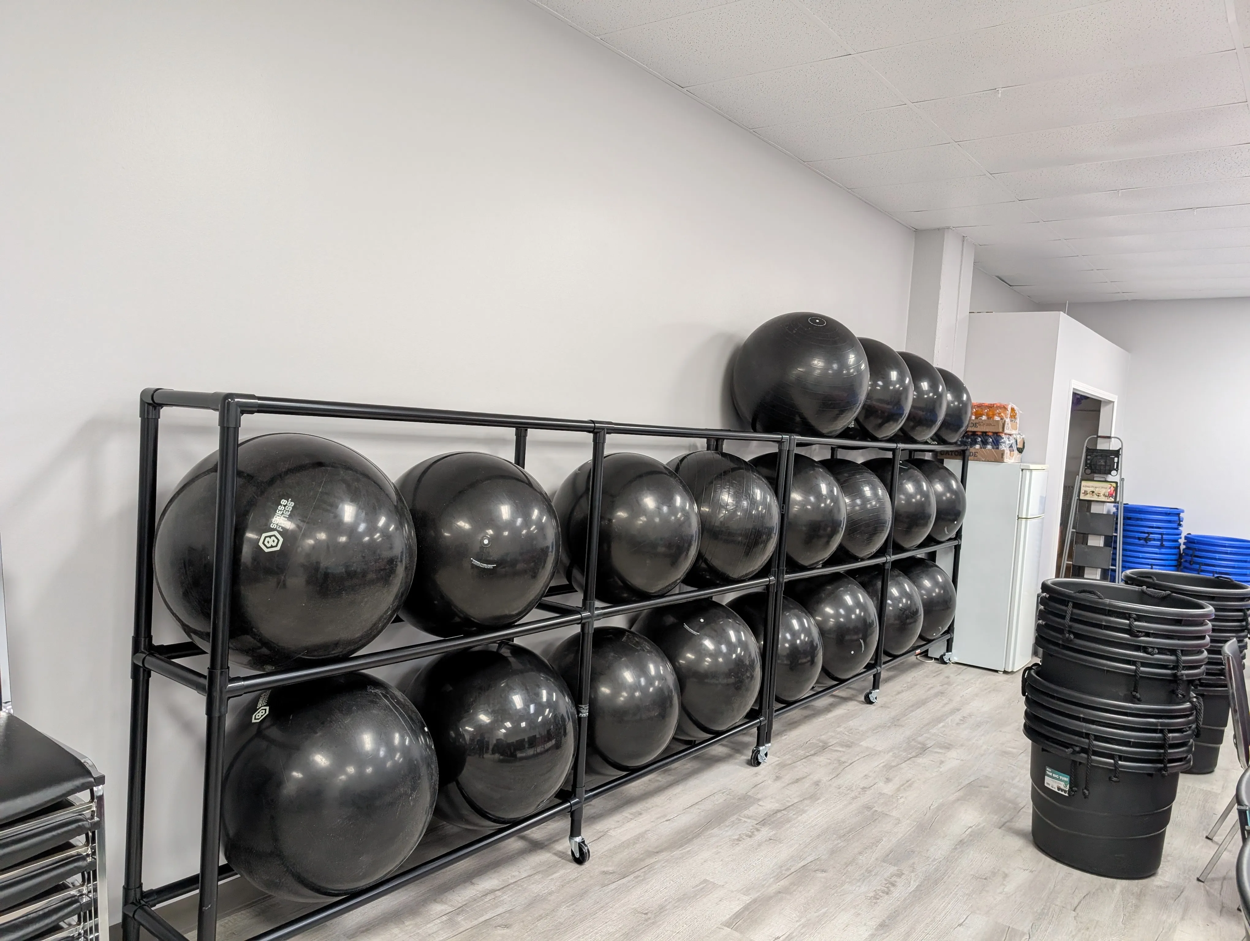 A rack full of large black exercise balls used for the HUB’s cardio drumming class.