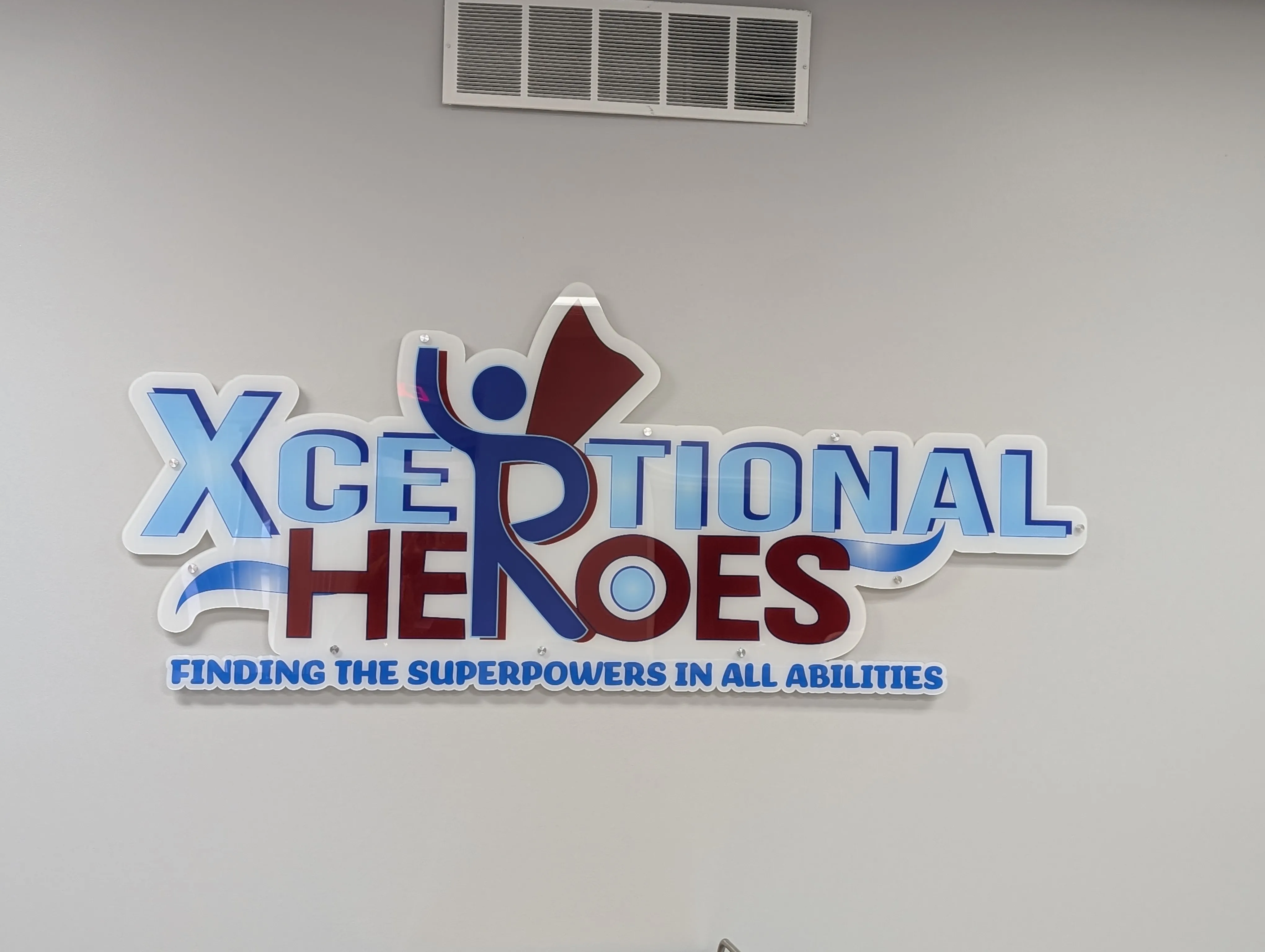 The Xceptional Heroes “Finding the Superpowers in all Abilities” logo mounted on the wall of the HUB.